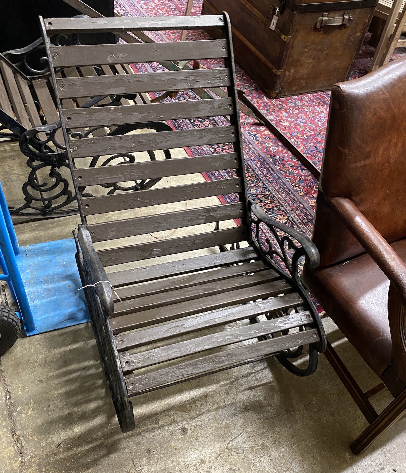 A pair of cast metal slatted wood rocking garden chairs, width 62cm, depth 86cm, height 88cm